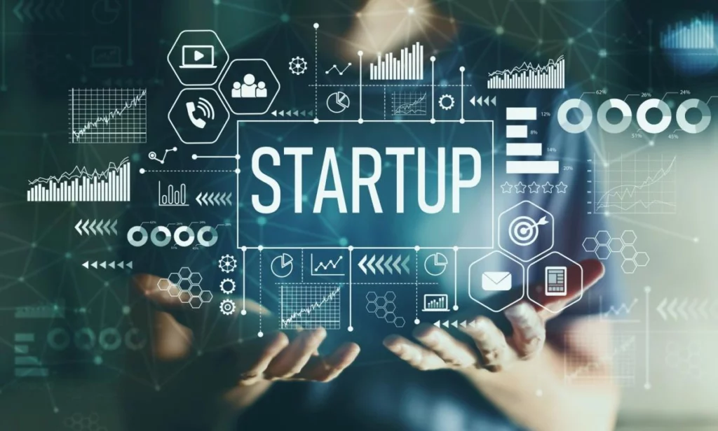 Hand pointing at a digital screen with the word STARTUP and icons